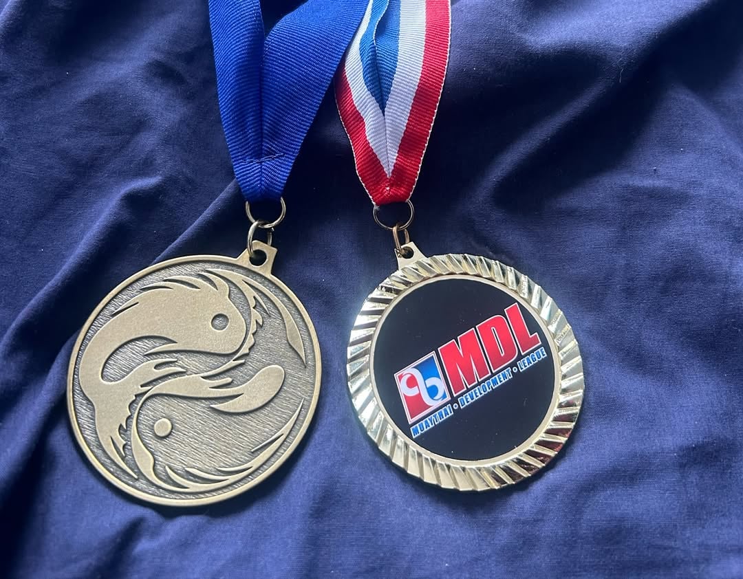 I keep getting asked what’s next as far as competitive martial arts and the answer is, nothing planned. In the first pic On the left is a medal I got from my first Smoker/Exhibition and on the right is from the most recent. I restarted my martial arts journey in 2016 with one goal in mind and that was to Learn in a place where I can only focus on the tasks at hand or I wouldn’t progress. To keep the rest of life outside while I was in the dojo. I needed to get away from what I didn’t know at the time was depression having me in a chokehold. I never had the biggest motivation to compete. I sometimes get that spark but honestly it always escapes me and to be honest I am a believer that if you want to do something like competitive fighting, you have to put everything into it and I am into too many things to dedicate myself in that way.Now, I have no doubt in my mind that so long as God gives me breath and the ability to move, I will train. My goal has now changed from just wanting to learn and escape to continuing to learn and helping build up others around me. That is why I am blessed and thankful to be training with the amazing @travel.train.teach where the philosophy is Travel The World, Train With the Best and Teach your community. I love the idea of building others up and that’s what I’m on in 2025 forward but as for competing, I’m not there. Though never say Never#martialarts #blessed #life #grateful