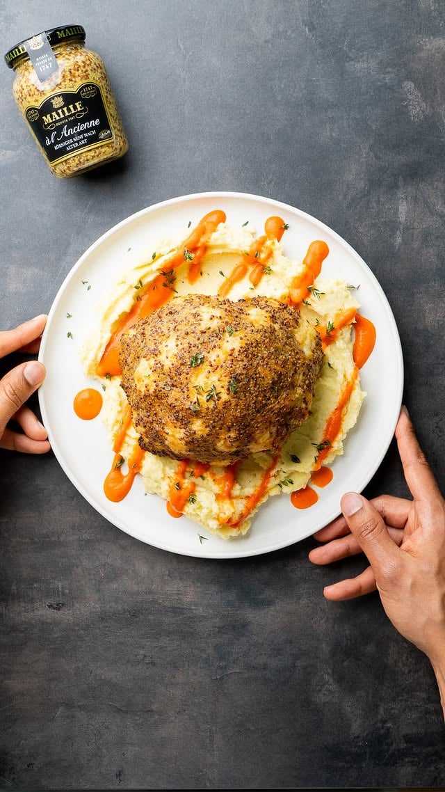 Anzeige | Heute wird mein Wohnzimmer in ein französisches Restaurant verwandelt. Auf der Karte: Blumenkohl mit Senfkruste auf cremigem Pommes Purée und einer süß-aromatischen Paprika-Sauce. Der Maille Dijon Senf nach alter Art verleiht das gewisse Extra. Verdient dieses Gericht das Maille Gütesiegel?🍽 Portionen: 1-2 | 🔥 Schwierigkeit: mittelBlumenkohl mit Senfkruste📃 ZUTATEN1 BlumenkohlSenfkruste4 EL Maille Dijon Senf nach alter Art4 EL Olivenöl1 EL Paniermehl1 EL frischer Thymian, gehackt1 TL Zitronenabrieb1 Knoblauchzehe, geriebenSchwarzer Pfeffer👨🏽‍🍳 ZUBEREITUNG1. Backofen auf 200 °C vorheizen.2. Blumenkohl waschen, Blätter entfernen und für 10 Min in einem Topf kochen. Anschließend ausdampfen lassen.3. Zutaten für die Senfkruste in einer Schüssel verrühren und auf den Blumenkohls auftragen.4. Blumenkohl bei 200 °C Umluft 25 Min backen, bis die Kruste goldbraun ist.Paprika-Sauce📃 ZUTATEN2 rote Paprika, halbiert und entkernt1 Schalotte, geviertelt1 Knoblauchzehe150 ml pflanzliche Sahne1 TL Ahornsirup1 EL OlivenölSalz, PfefferZitronensaft👨🏽‍🍳ZUBEREITUNG1. Paprika mit Schalotte und Knoblauch im Ofen für ca. 25 Min rösten. Anschließend kurz abkühlen und Haut der Paprika lösen.2. Paprika mit Schalotte, Knoblauch, pflanzlicher Sahne und Ahornsirup pürieren.3. Mit Salz, Pfeffer und etwas Zitronensaft abschmecken.Pommes Purée📃 ZUTATEN500 g mehligkochende Kartoffeln1 EL Salz80 ml pflanzliche Sahne60 g vegane Butter, geschmolzen1 Prise MuskatnussSalz👨🏽‍🍳 ZUBEREITUNG1. Kartoffeln in Salzwasser für 25 Min weich kochen, dann abgießen und ausdampfen lassen.2. Kartoffeln pellen und durch Kartoffelpresse drücken.3. Pflanzliche Sahne erhitzen und mit einem Schneebesen unter die Kartoffeln rühren.4. Geschmolzene Butter einarbeiten, mit Salz und Muskat abschmecken.Bon appétit!#Maille #MailleCulinaryCritic #AD by @veganewunder